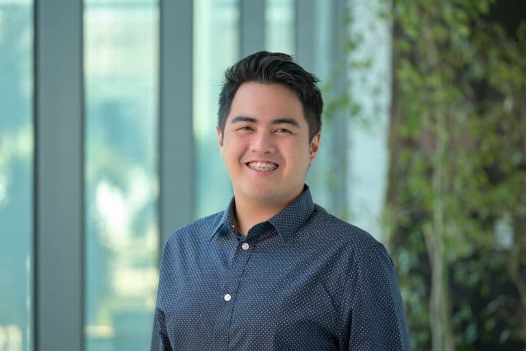 Pinoy scientist Neil Joshua Limbaga is young man with dark hair, wearing a navy blue patterned button-up shirt.