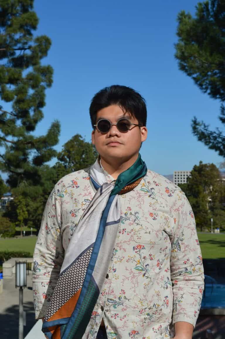 Pinoy scientist Juan Salvador Dantis wearing round sunglasses, a floral-patterned shirt, and a colorful scarf.