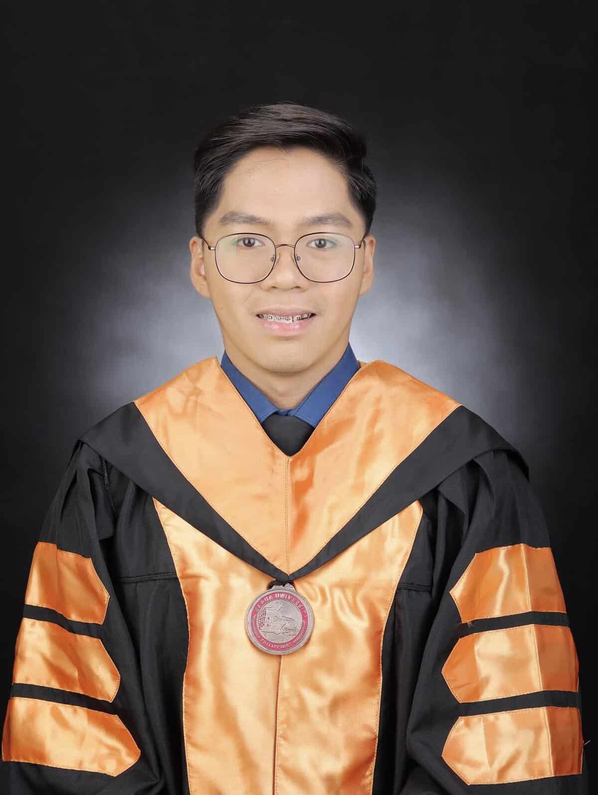 Pinoy scientist Zoren Mabunga is wearing a black graduation gown with orange accents